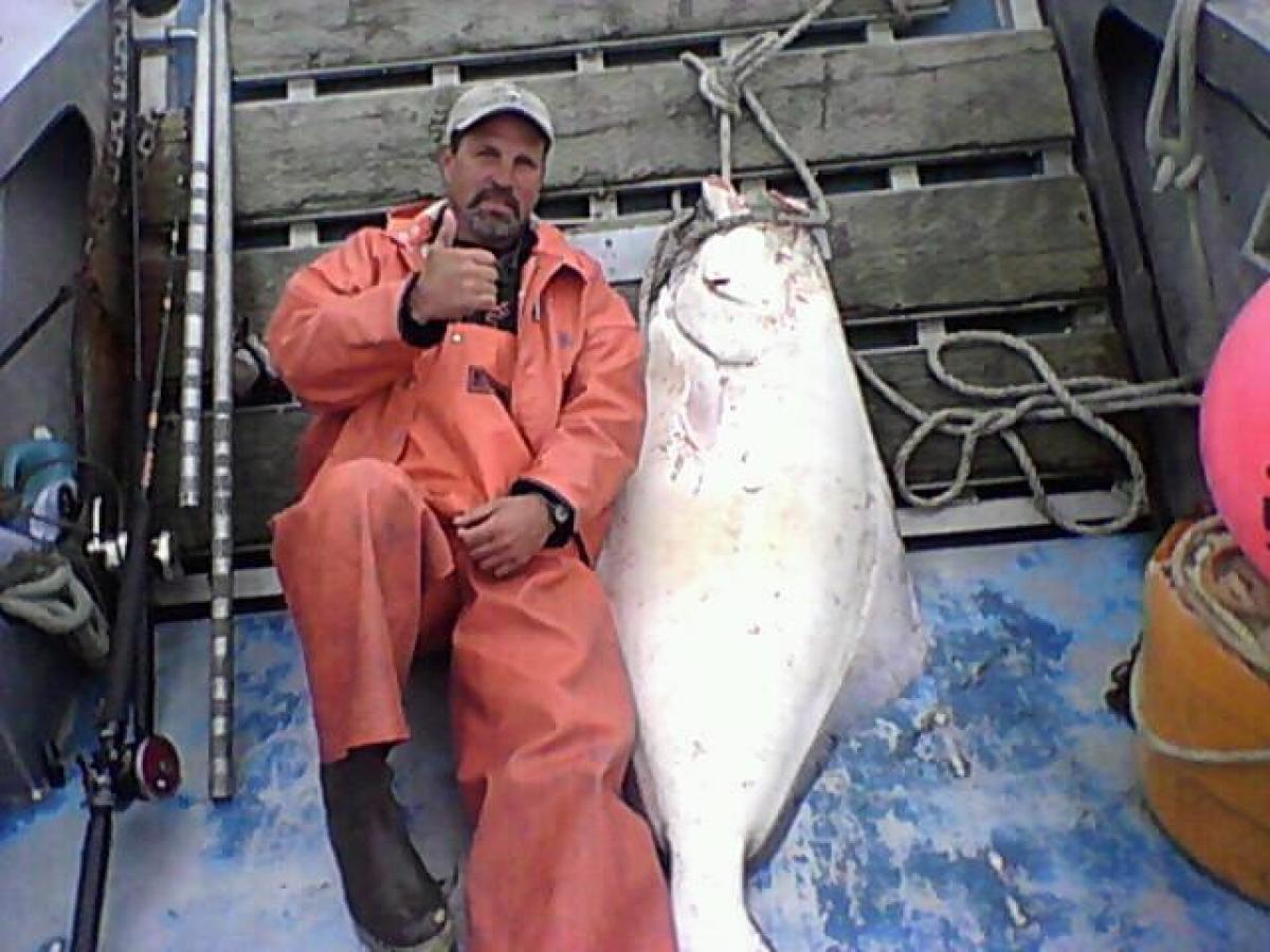 Capt Bill lounging with a Halibut