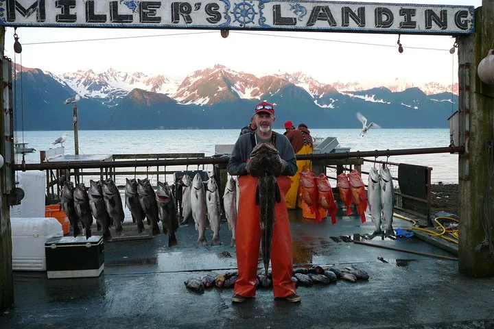 Capt holding a Lingcod with the rest of the catch on the line