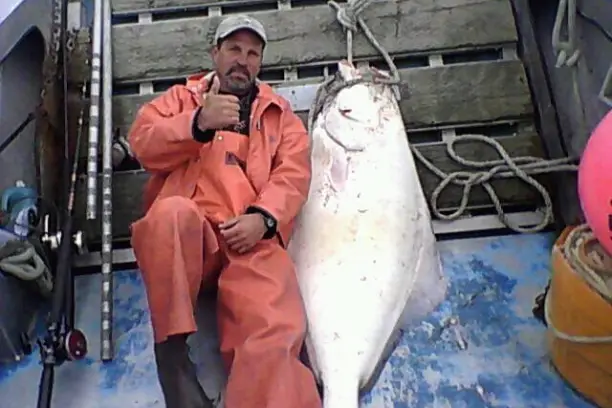 Captain Bill lounging with his Halibut buddy.
