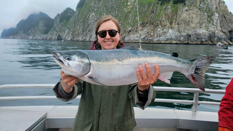 abby holding a fish in the water
