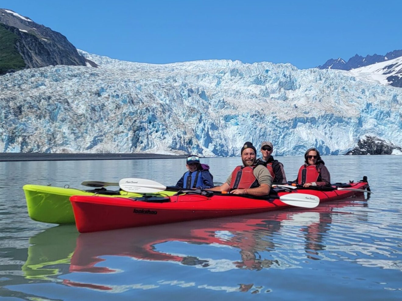 a small boat in a body of water with a mountain in the background