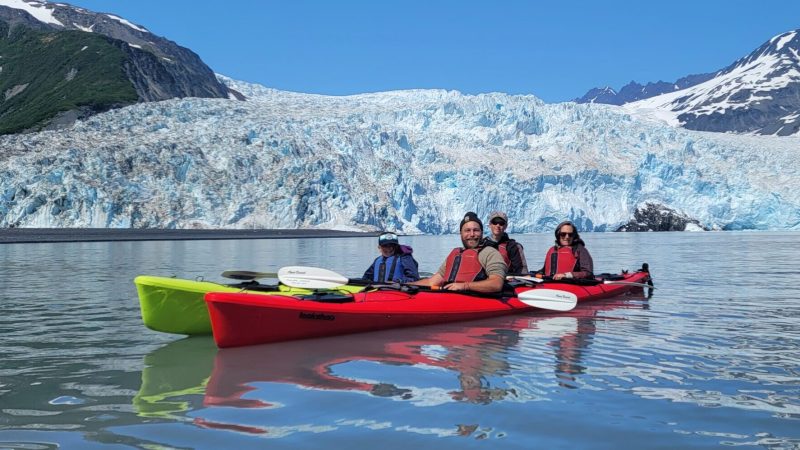 a small boat in a body of water with a mountain in the background