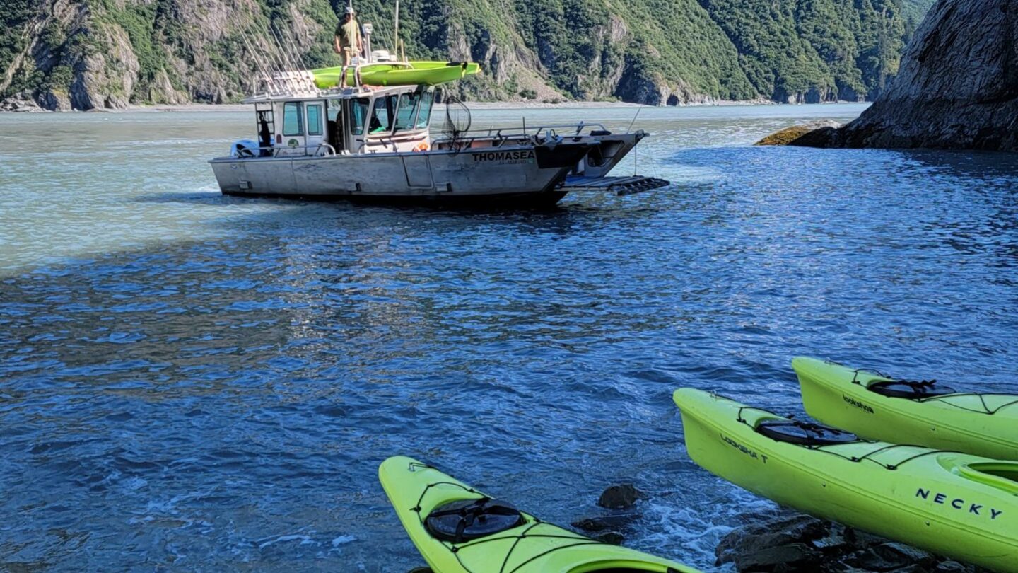 a green boat on a body of water