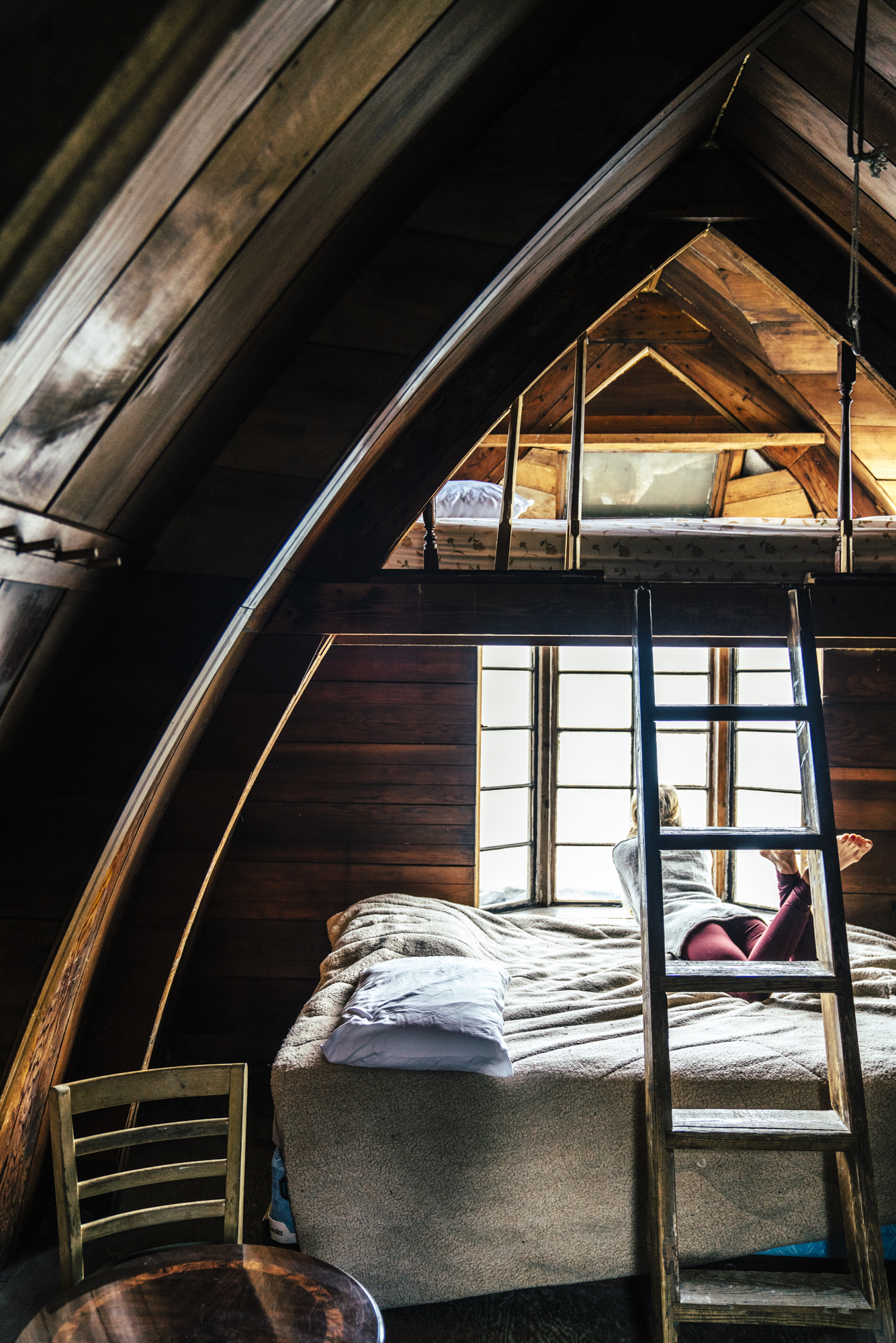 Girl laying in window of Seaside Camping Cabin and looking out at the baySeaside Beach Seward Alaska Kayaking Fishing Lodging Camping Guided Trips