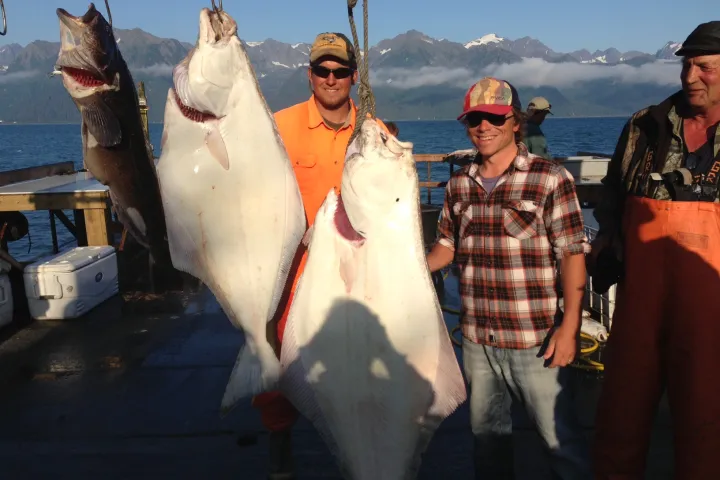 a group of people standing next to a person holding a fish