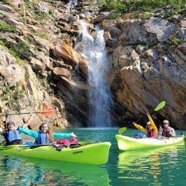 a group of people riding on the back of a boat in the water