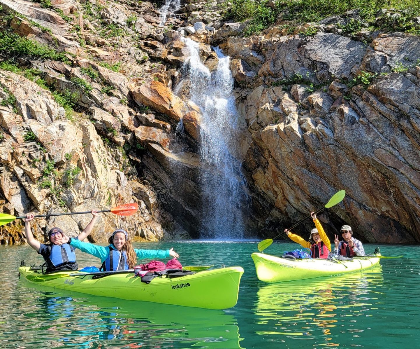 a group of people riding on the back of a boat in the water