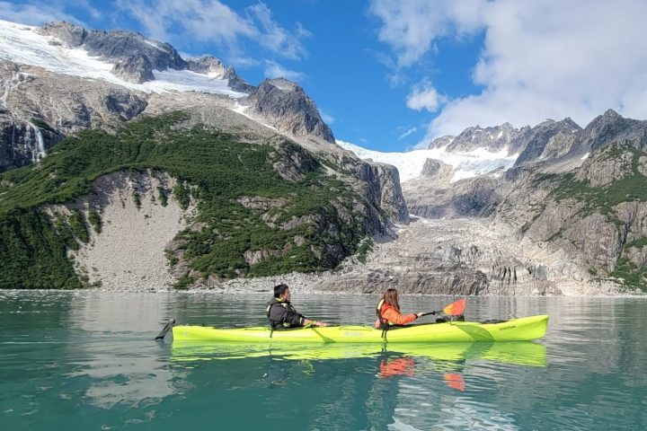 a group of people riding on the back of a boat in the water