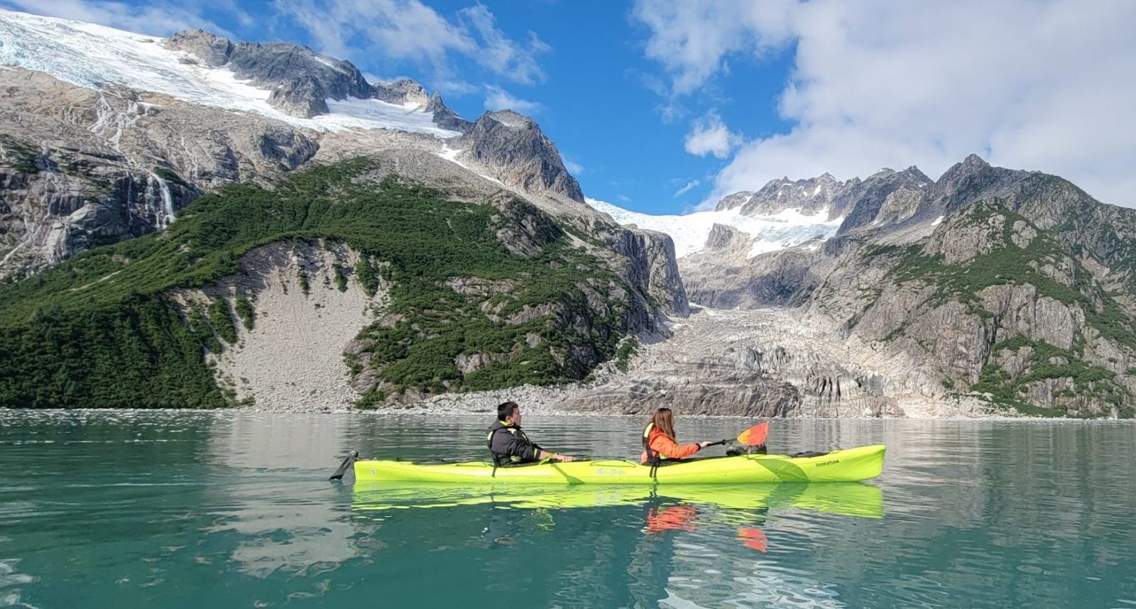 a group of people riding on the back of a boat in the water