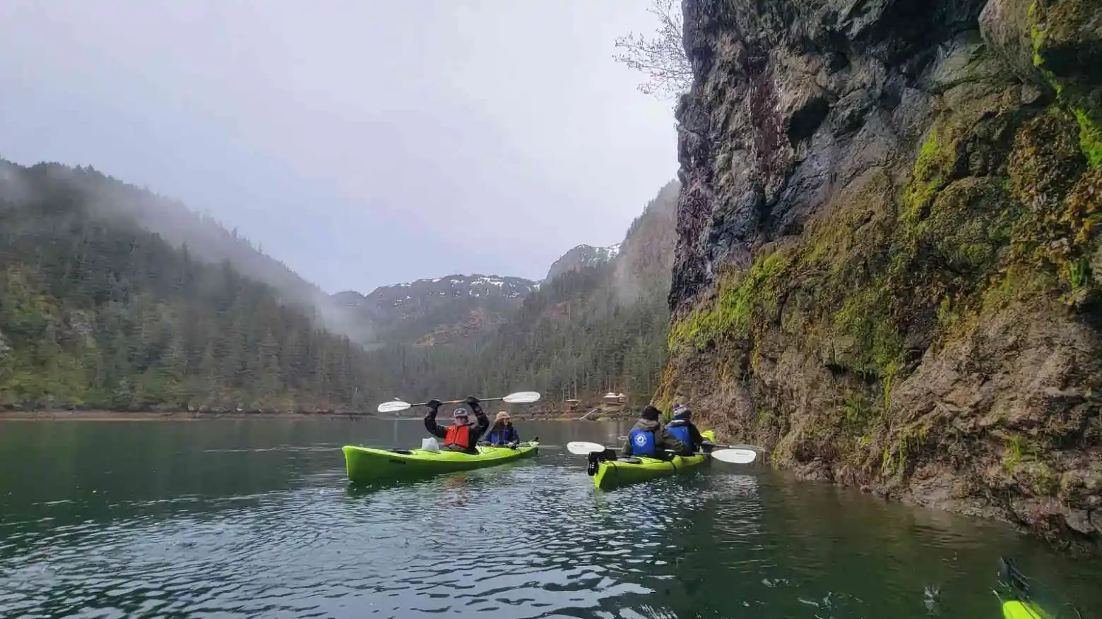 a man in a green boat on a lake