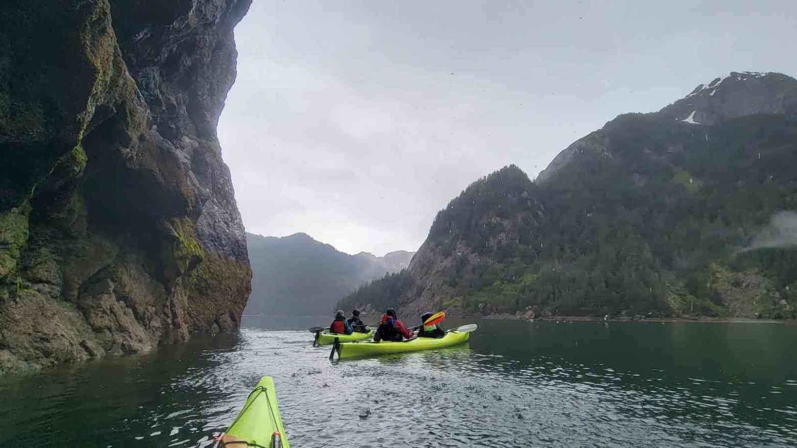 a small boat in a body of water with a mountain in the background
