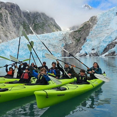 a group of people riding on the back of a boat in the water