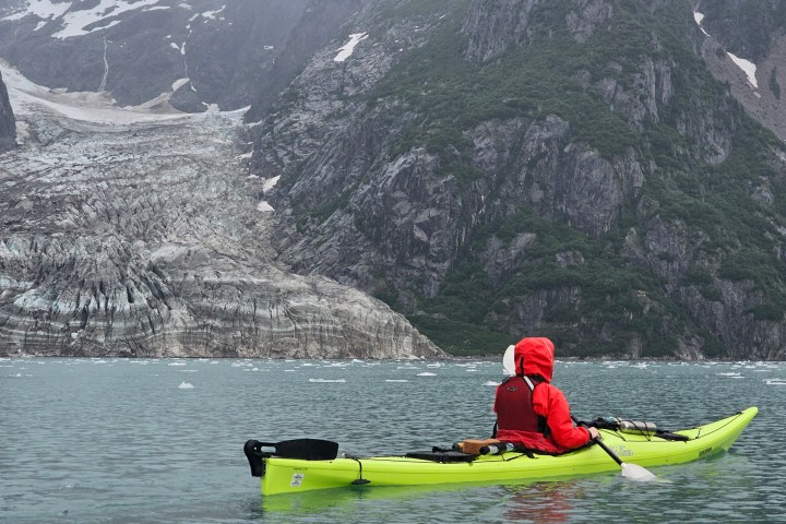 a man riding on the back of a boat in the water