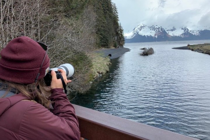 a group of people sitting next to a body of water