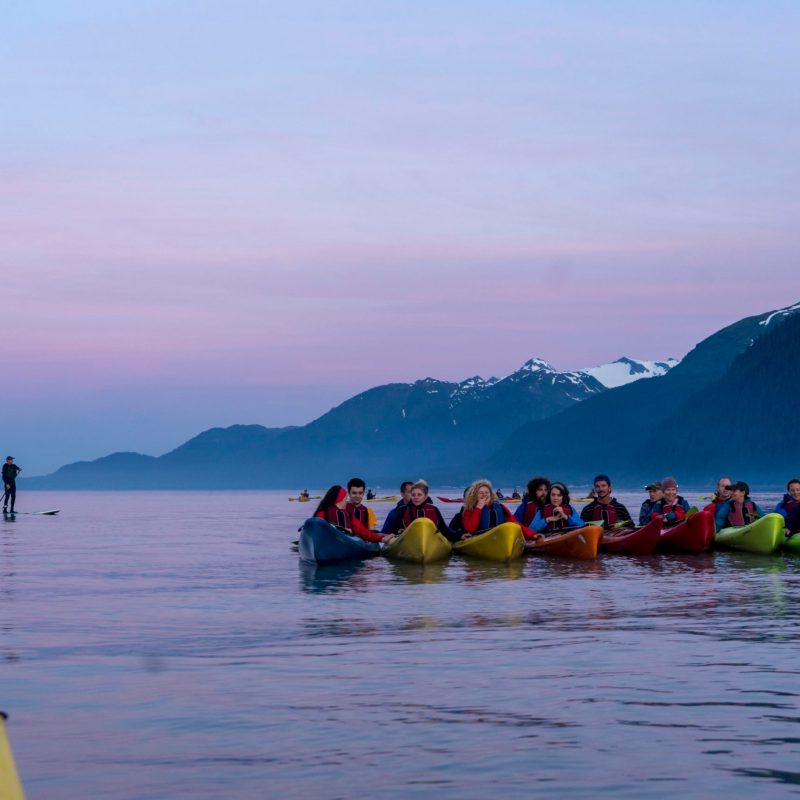 a group of people standing next to a body of water
