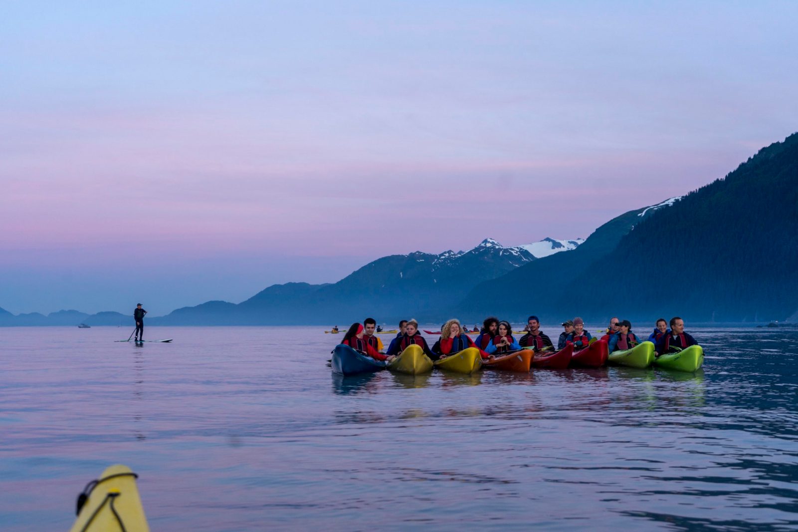 a group of people standing next to a body of water