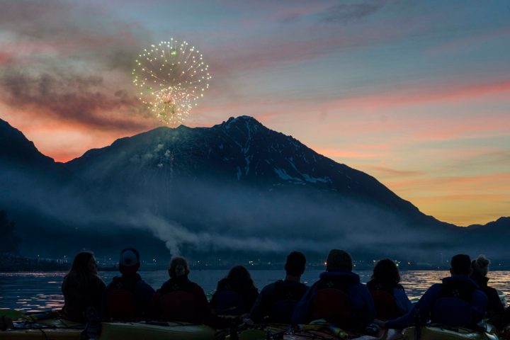 a group of people standing in front of a mountain