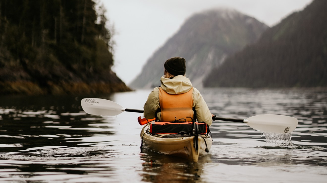 a person riding on the back of a boat in the water