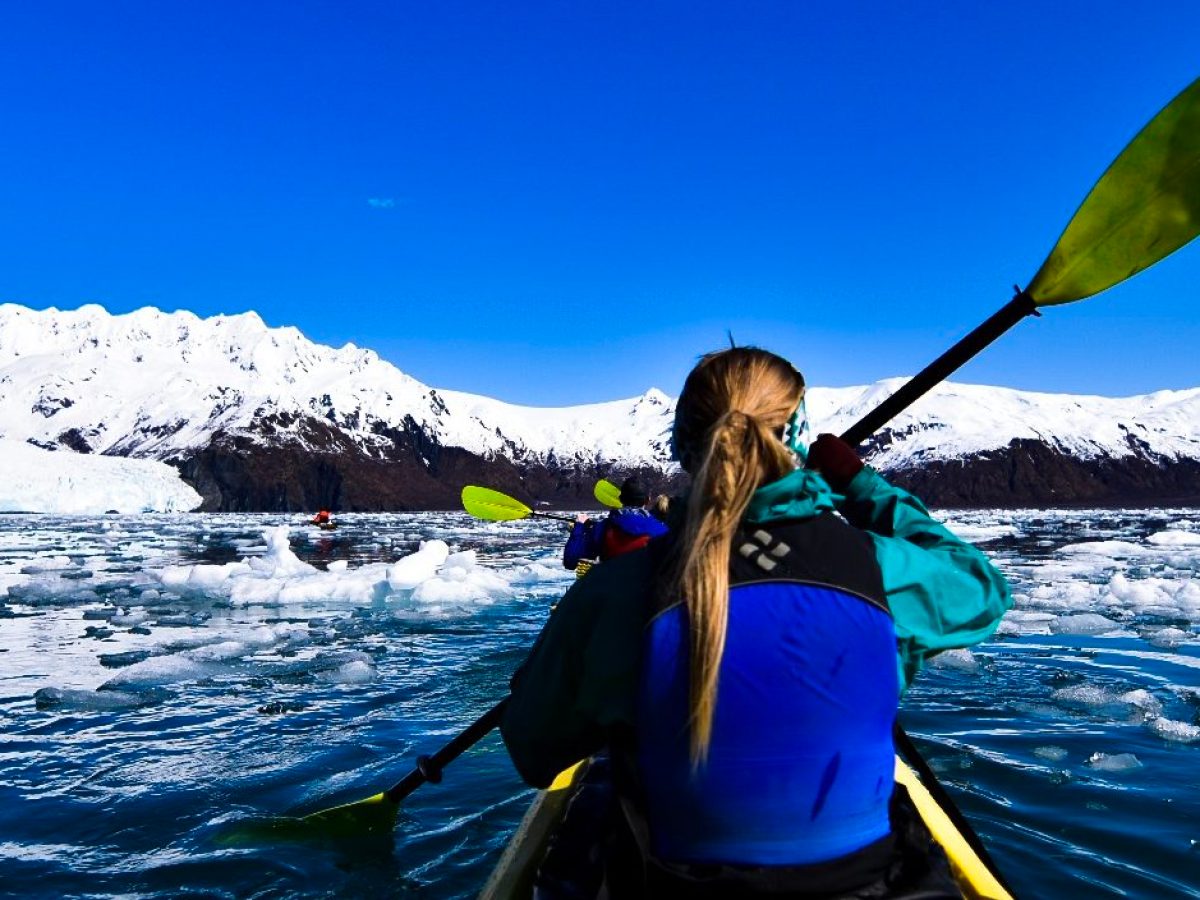A woman kayaking through ice water
