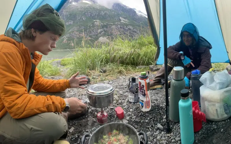 a man and a woman sitting at a table with food