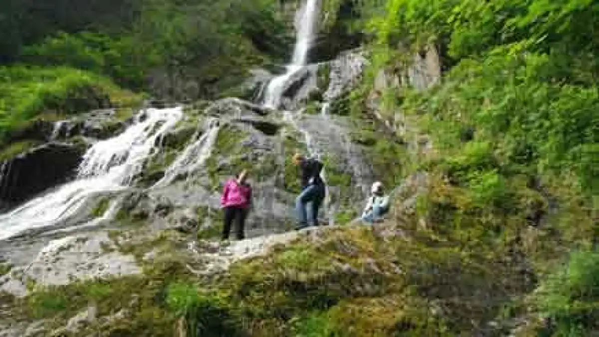 a group of people standing next to a waterfall