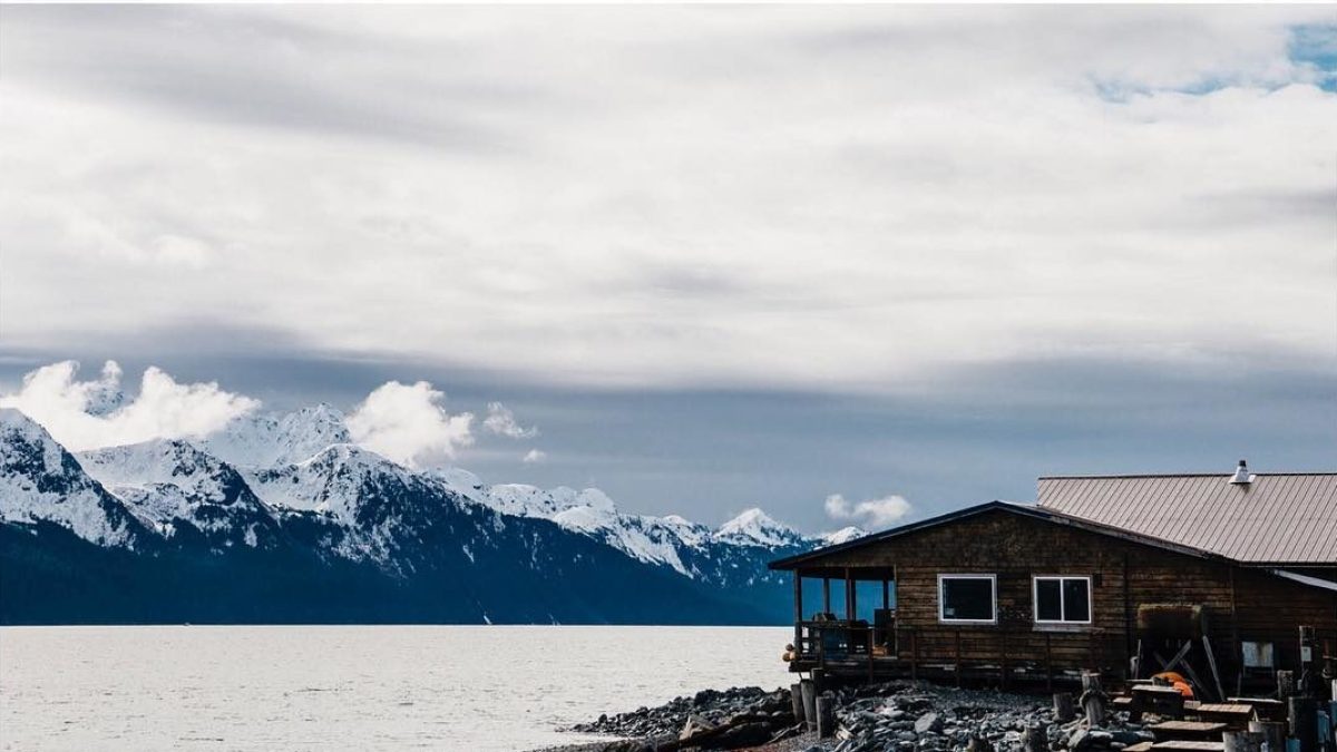 Cabin in Seward Alaska right by the water with the mountains in the background