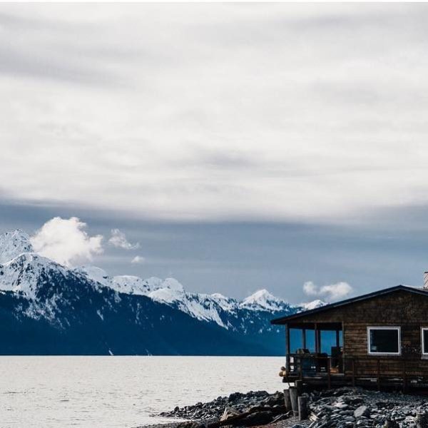 Cabin in Seward Alaska right by the water with the mountains in the background