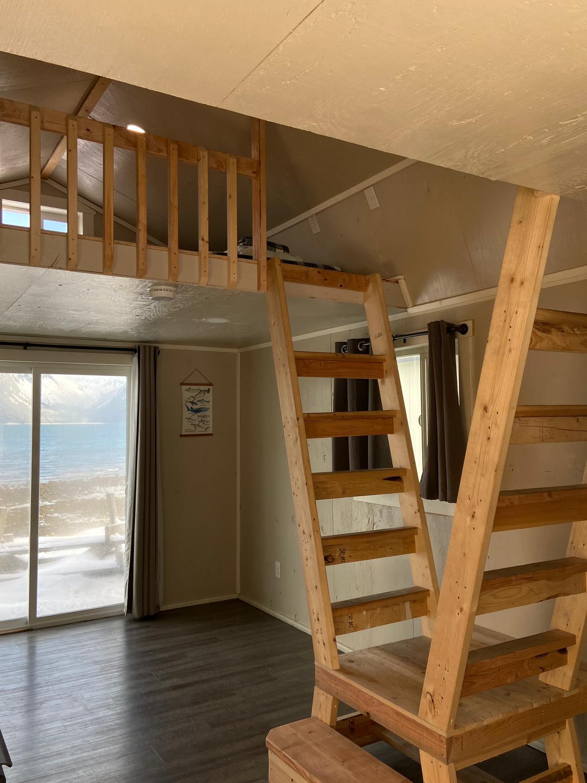 interior Beachfront Millers Landing cabin with sliding door facing the bay , loft rail guard and ladders