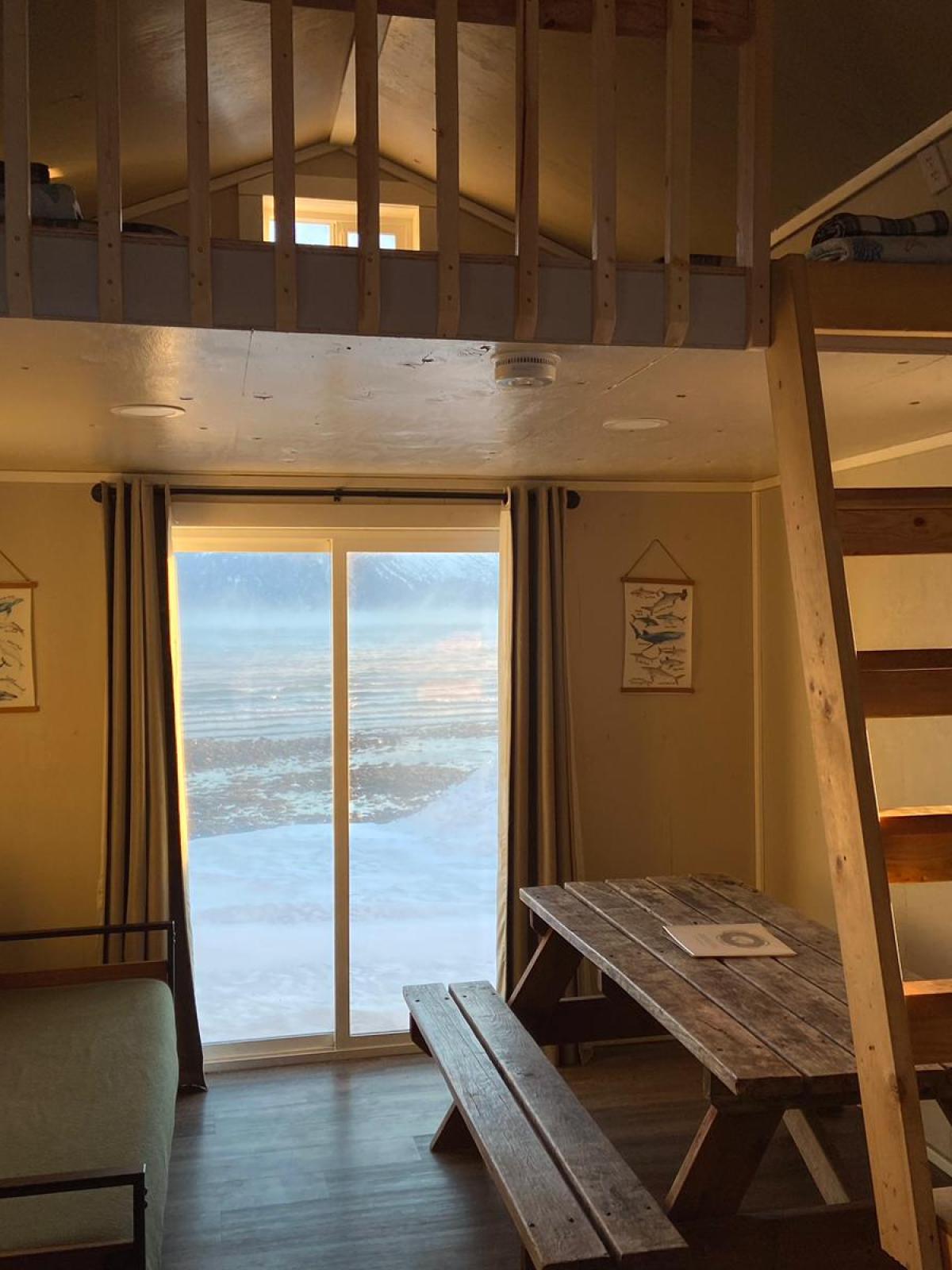 interior Beachfront Millers Landing cabin with bed, picnic table, loft rail guard and ladders