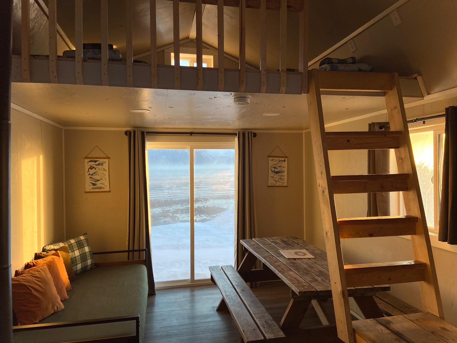 interior Beachfront Millers Landing cabin with bed, picnic table, loft rail guard and ladders