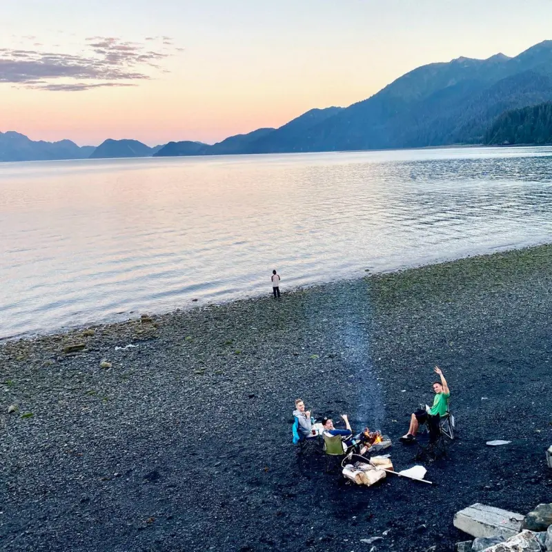 a group of people on a beach near a body of water