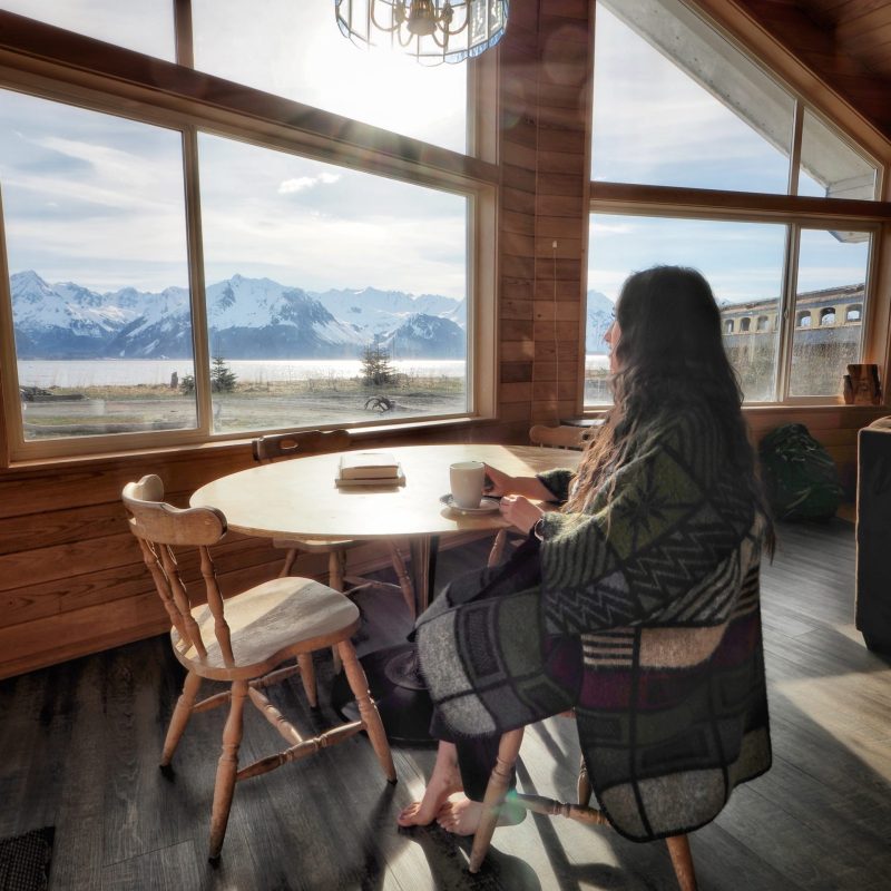 a woman standing in front of a windowSeaside Beach Seward Alaska Kayaking Fishing Lodging Camping Guided Trips