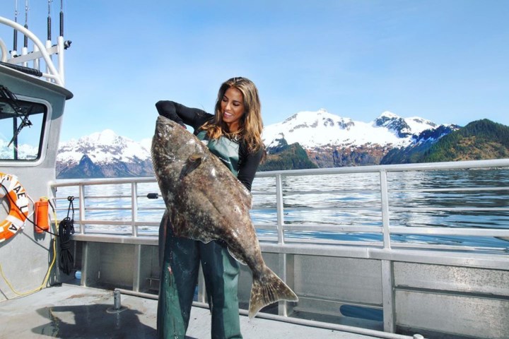 a statue of a man and a woman sitting at a dock