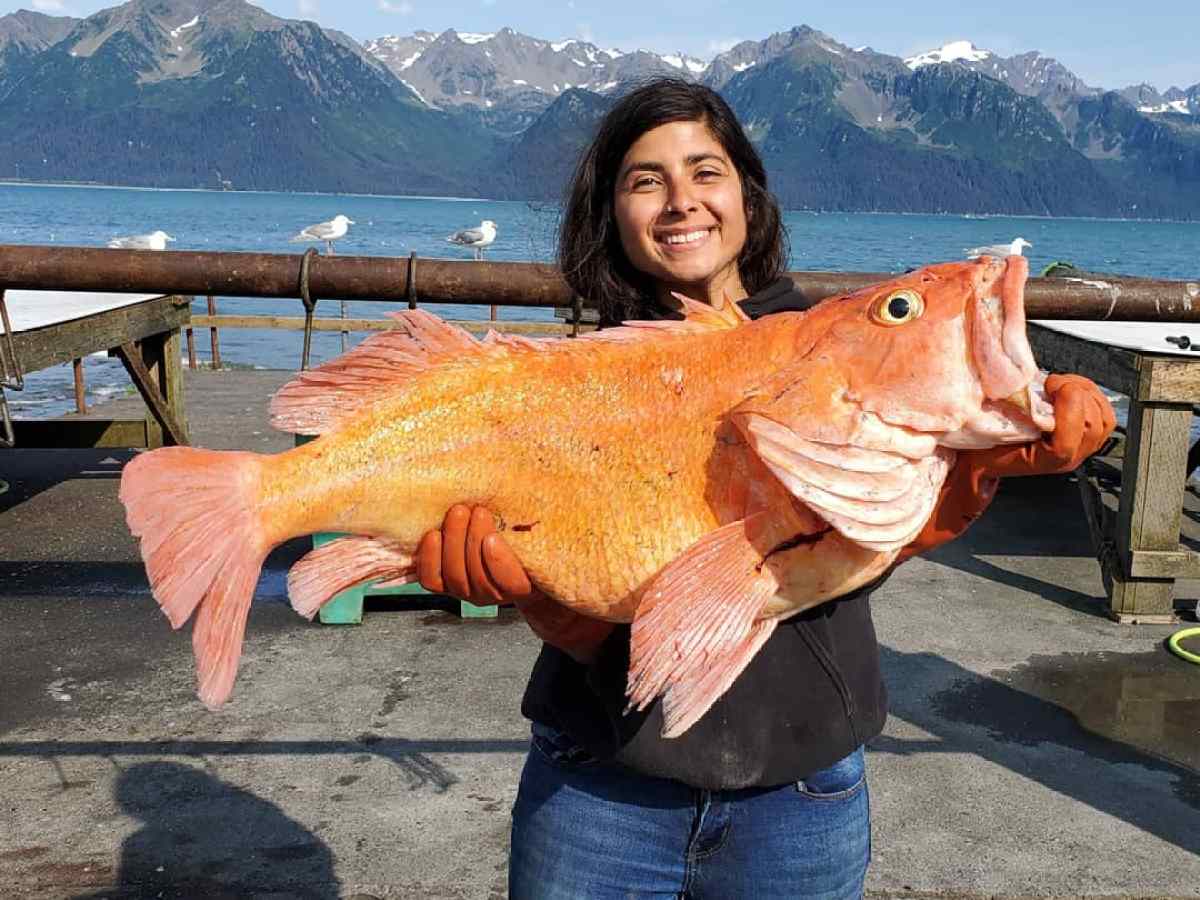 a woman standing in front of a body of water