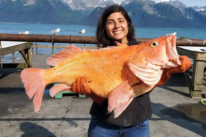 a woman standing in front of a body of water