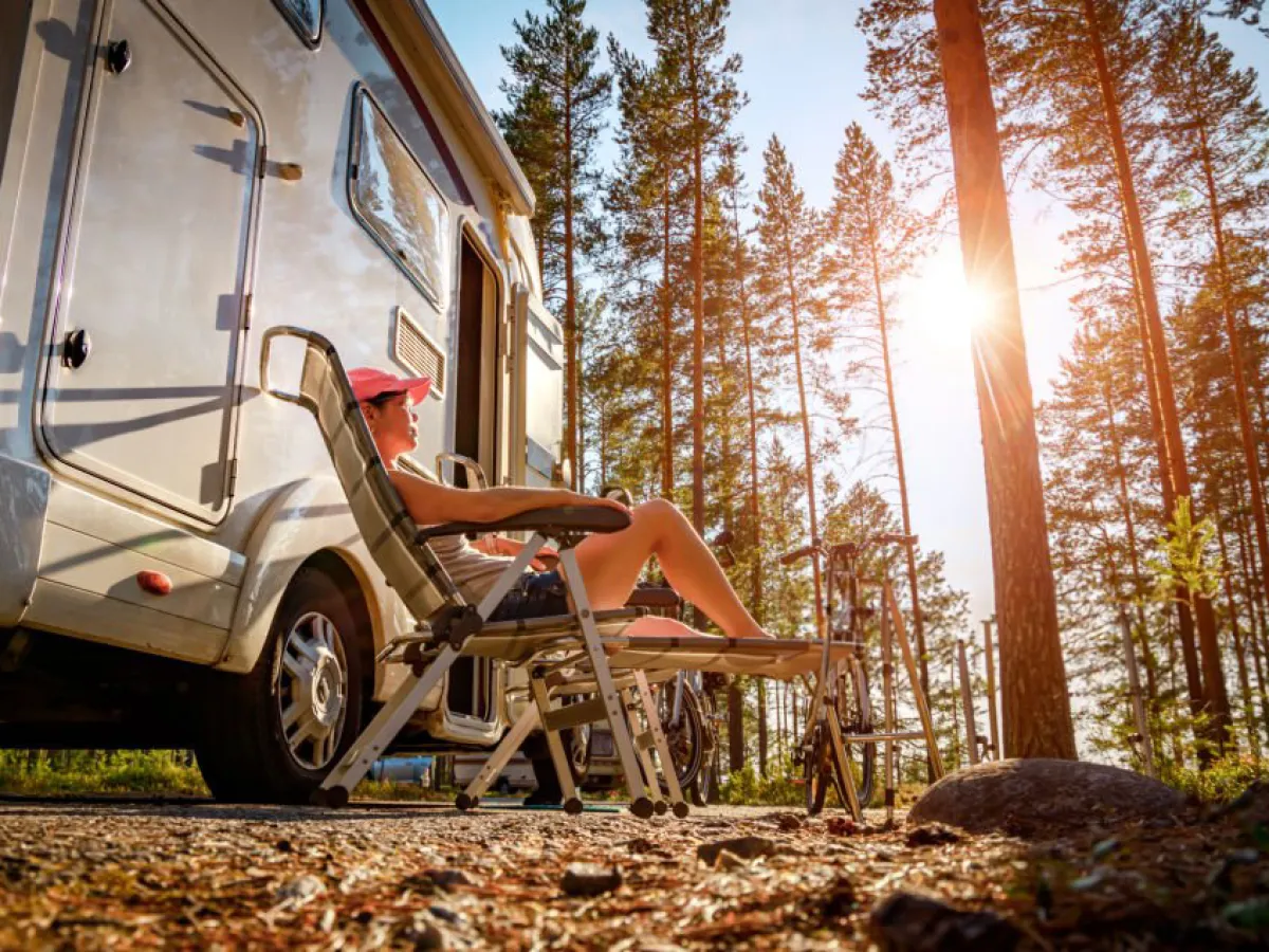 a person outside of an rv enjoying the sun through the treesMillers Landing Seward Alaska Beach Seaside