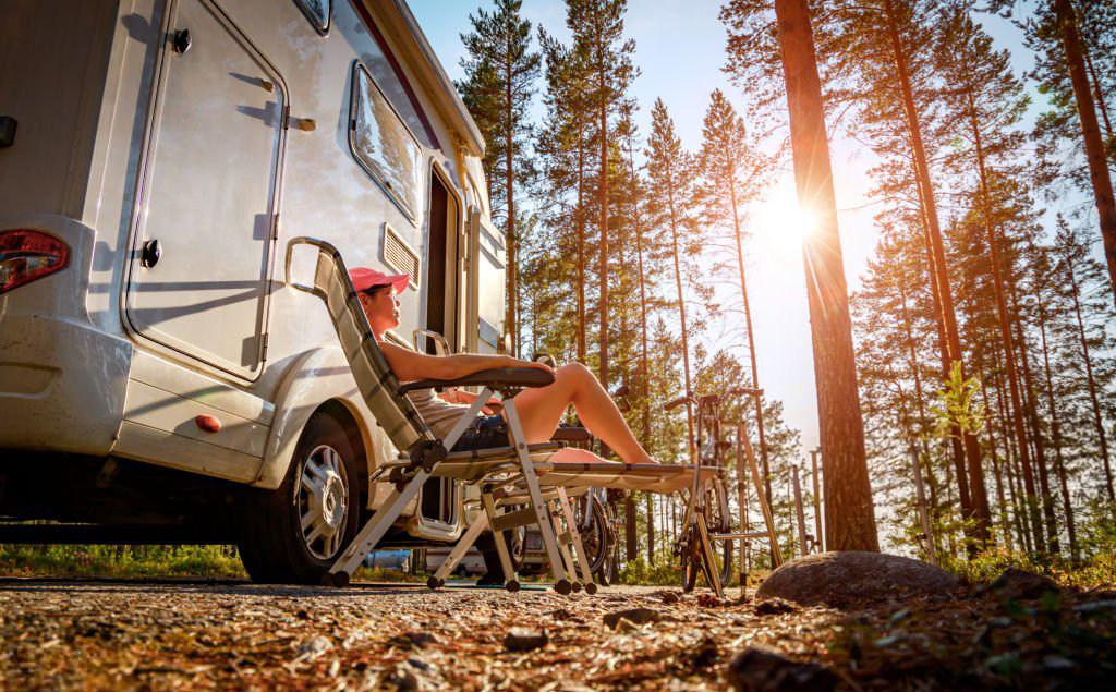 a person outside of an rv enjoying the sun through the treesMillers Landing Seward Alaska Beach Seaside