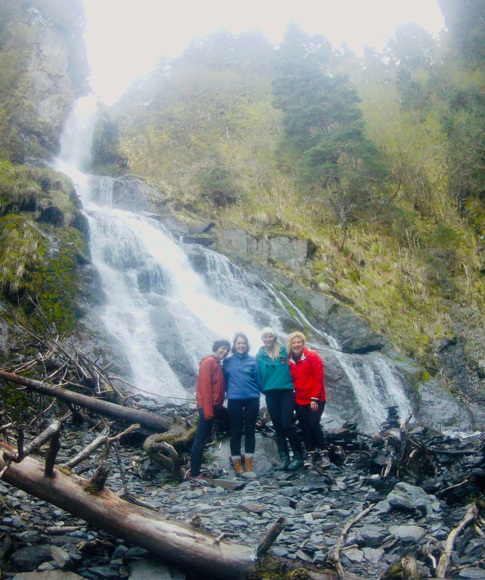 a train traveling down train tracks next to a waterfall