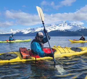a man flying a kite on a raft in a body of water