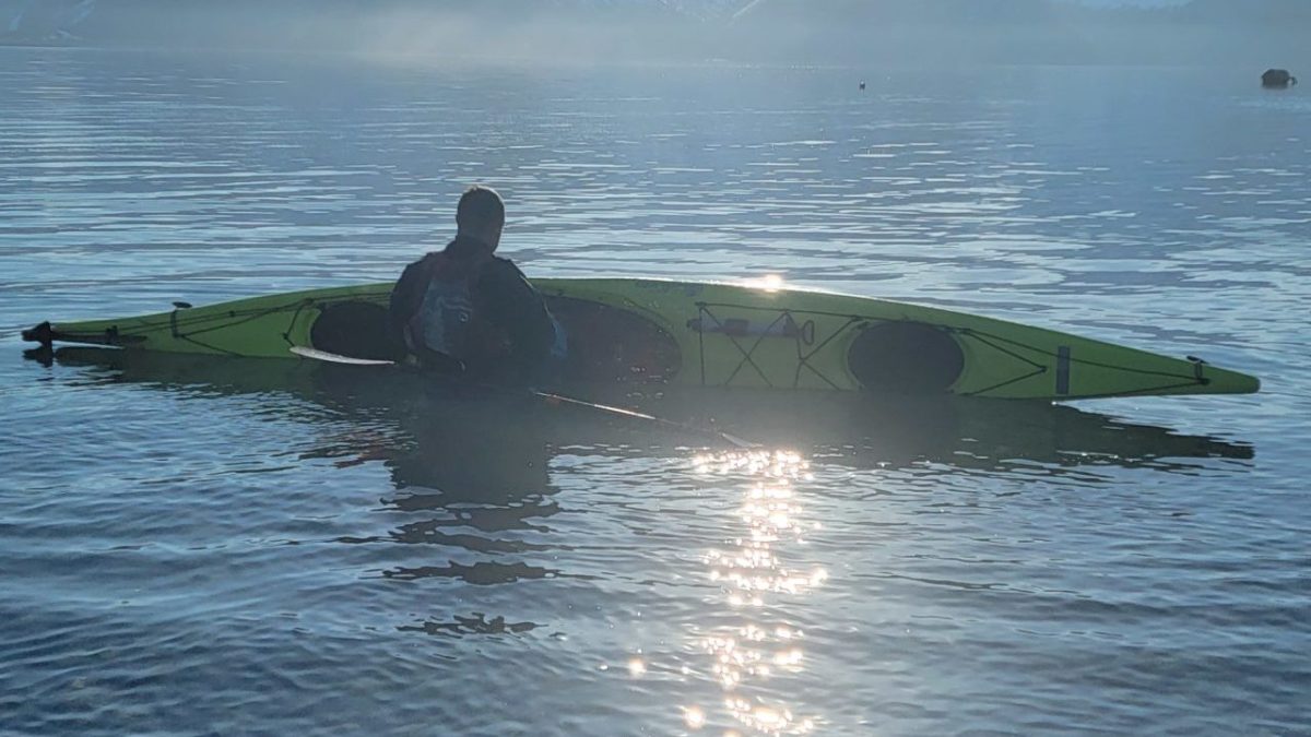 a man standing next to a body of water