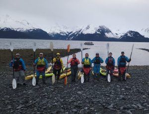 a group of people standing next to a body of water