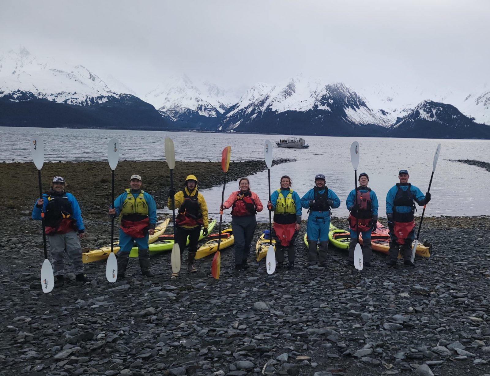 a group of people standing next to a body of water