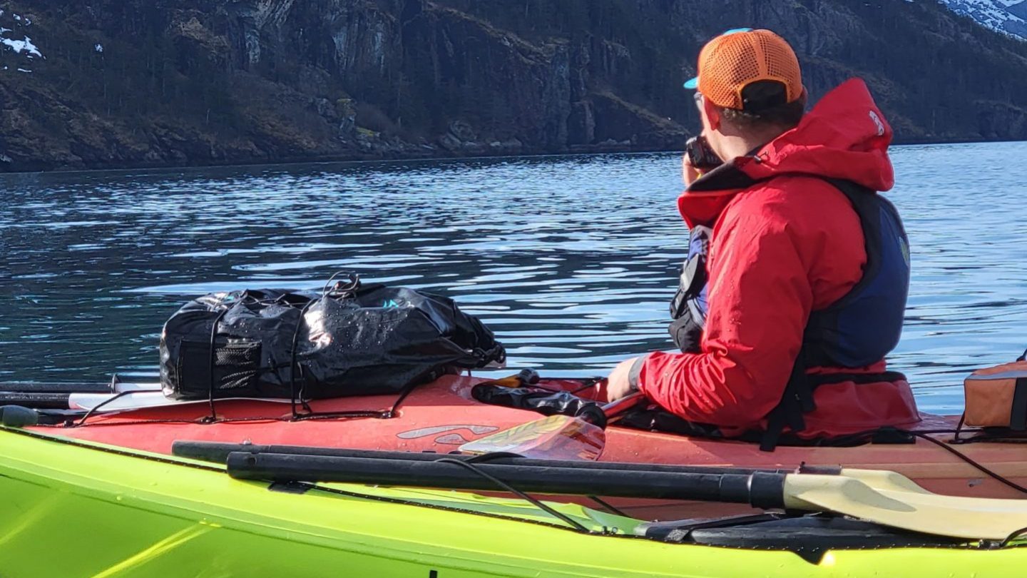 a man sitting in a boat on a body of water