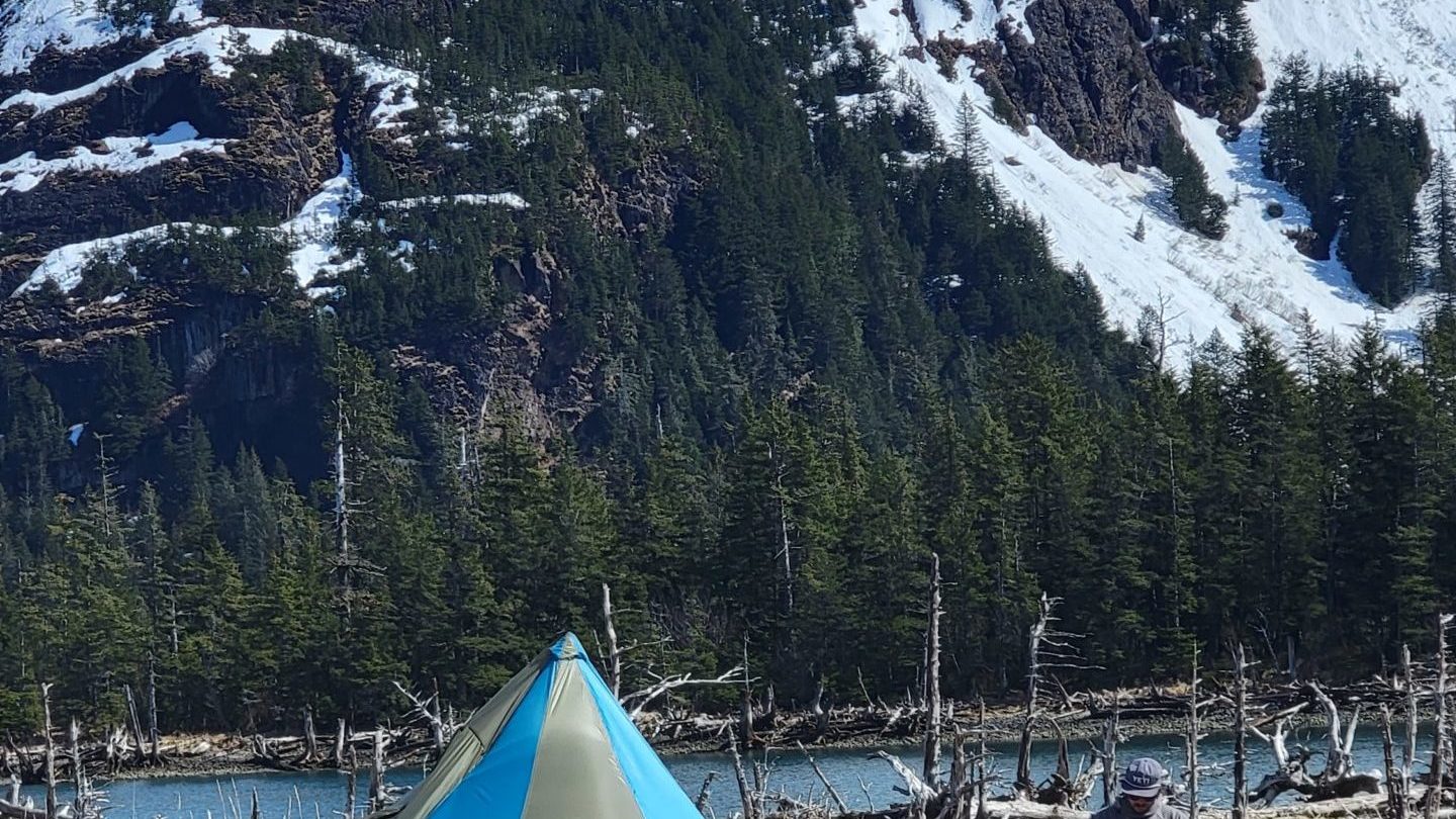 a tent on the side of a snow covered mountain
