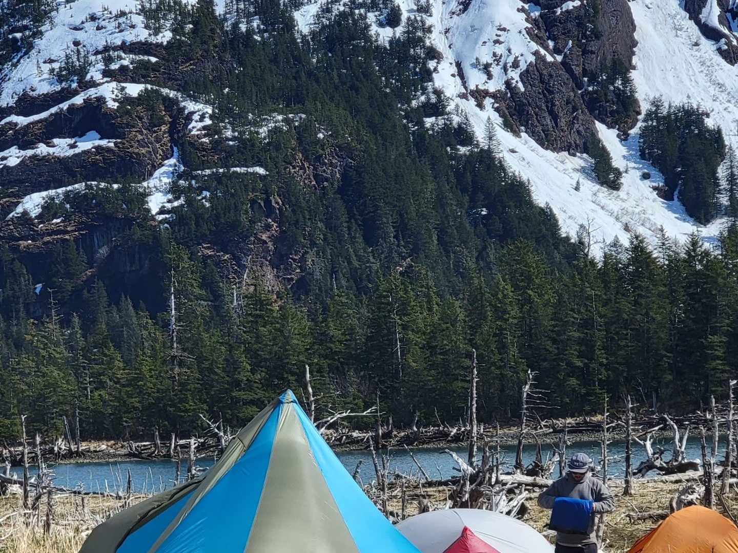 a tent on the side of a snow covered mountain