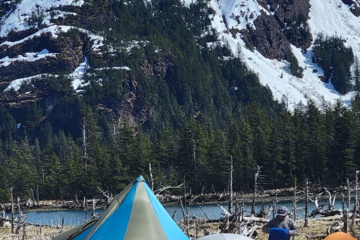 a tent on the side of a snow covered mountain