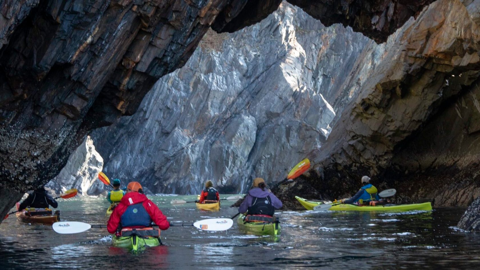 a group of people rowing a boat in the water