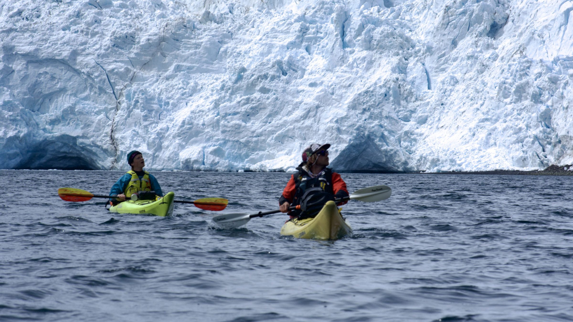 a group of people riding on the back of a boat in the water