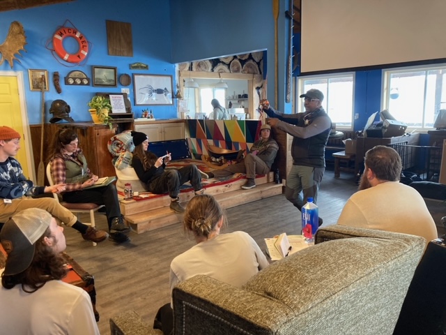 a group of people in class sitting and listening to the teacher