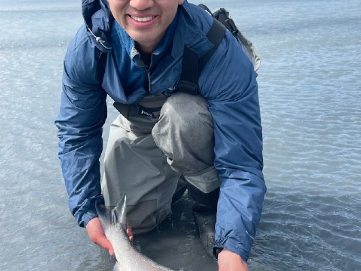 a man holding a fish in the water